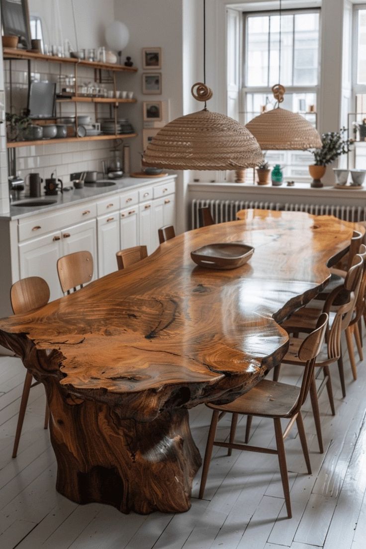 a wooden table surrounded by chairs in a room with white walls and wood flooring