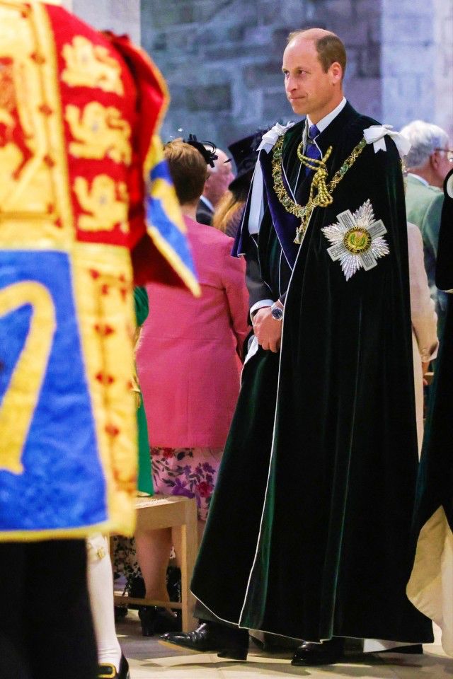 a man in a black robe standing next to other people