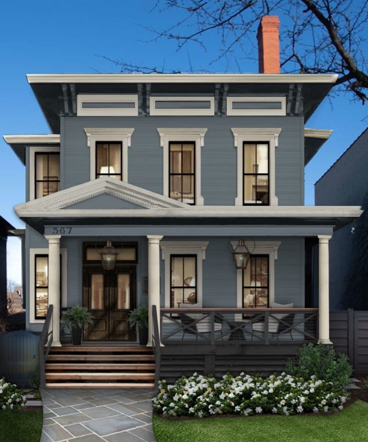 a large gray two story house with front porch and steps leading up to the second floor