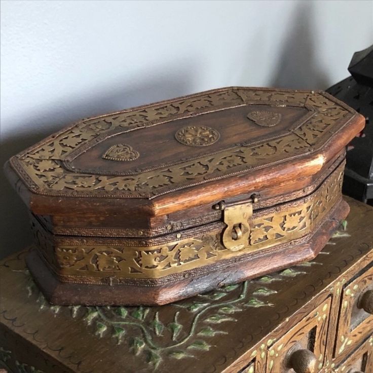 an old wooden box sitting on top of a dresser