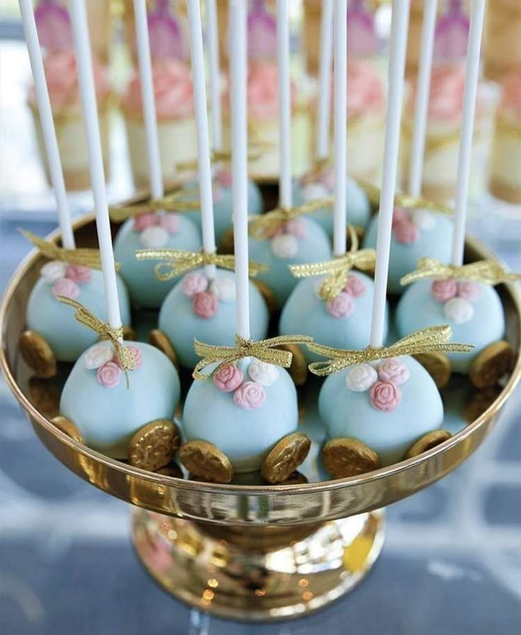 there are some cake pops with candles in the middle on a gold plated stand