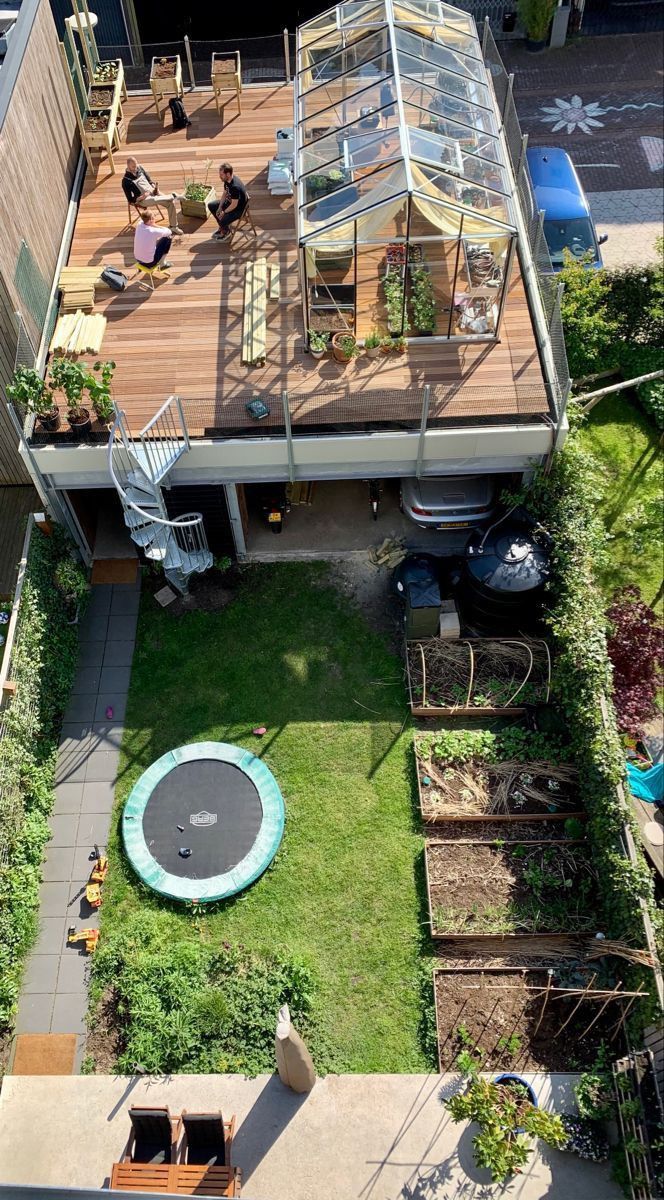 an aerial view of a backyard with a trampoline in the center and people sitting on it