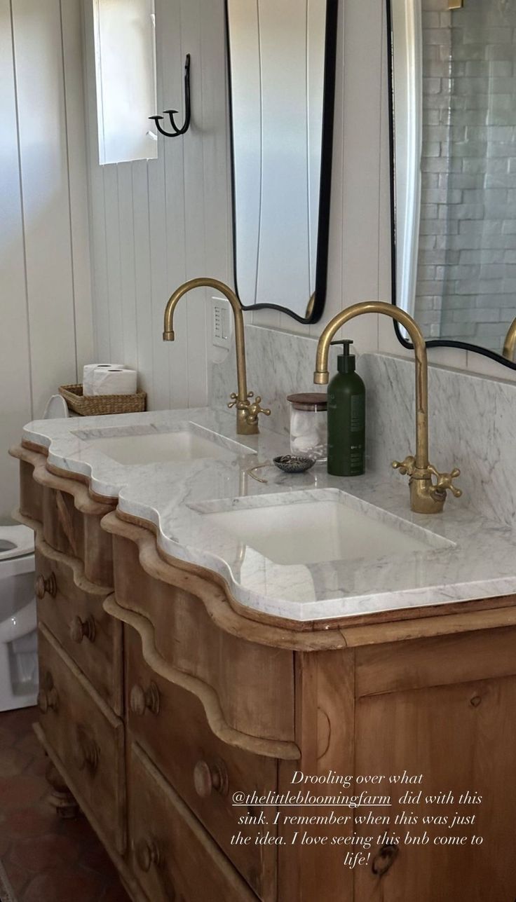 a bathroom with two sinks and mirrors on the wall