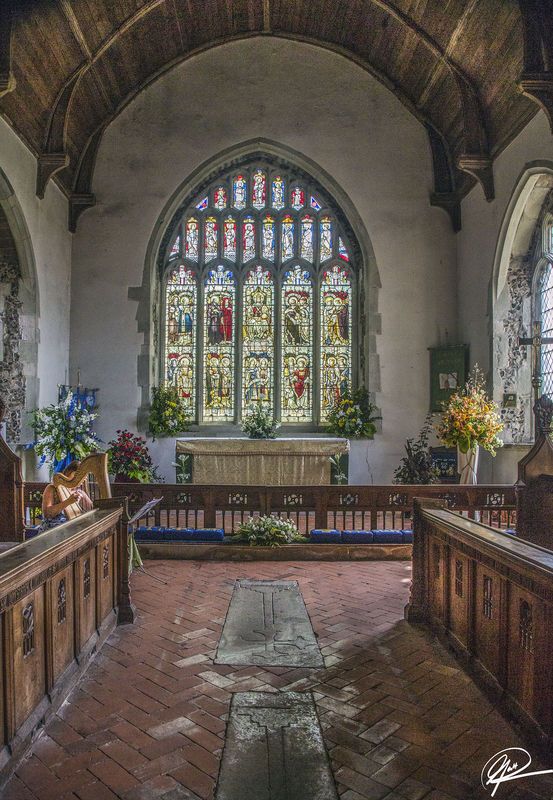 the inside of a church with stained glass windows and pews in front of it