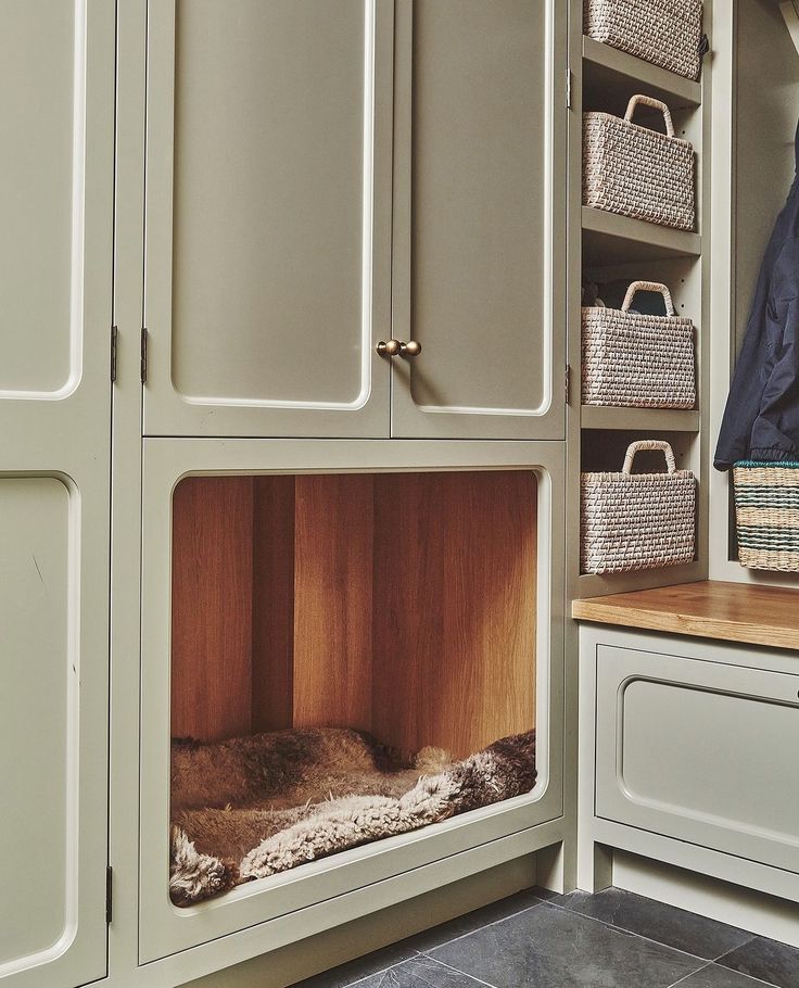 a dog bed in the corner of a closet with baskets on it's doors