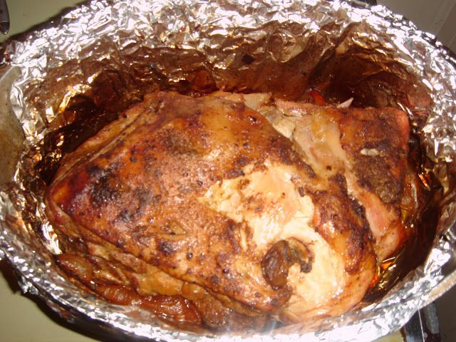 a cooked chicken in foil sitting on top of a stove