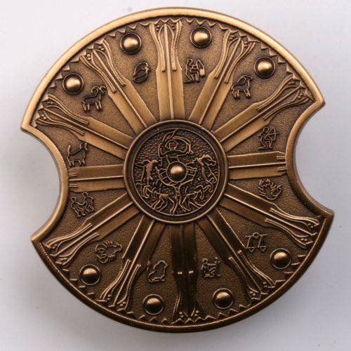 an ornate brass plate with zodiac signs and symbols on the front, set against a white background