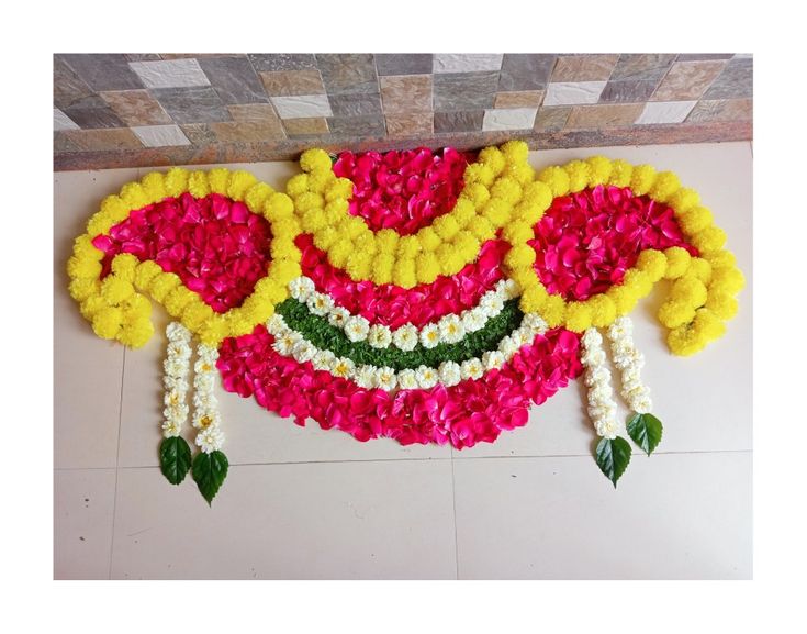 an arrangement of flowers arranged on the floor in front of a tiled wall and ceiling