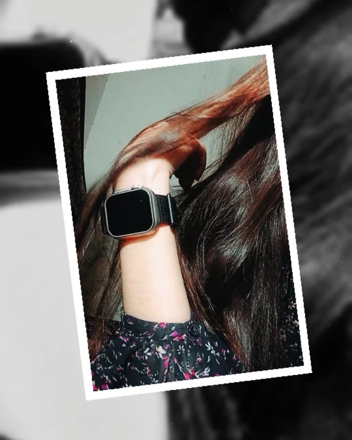 a woman with long brown hair wearing an apple watch