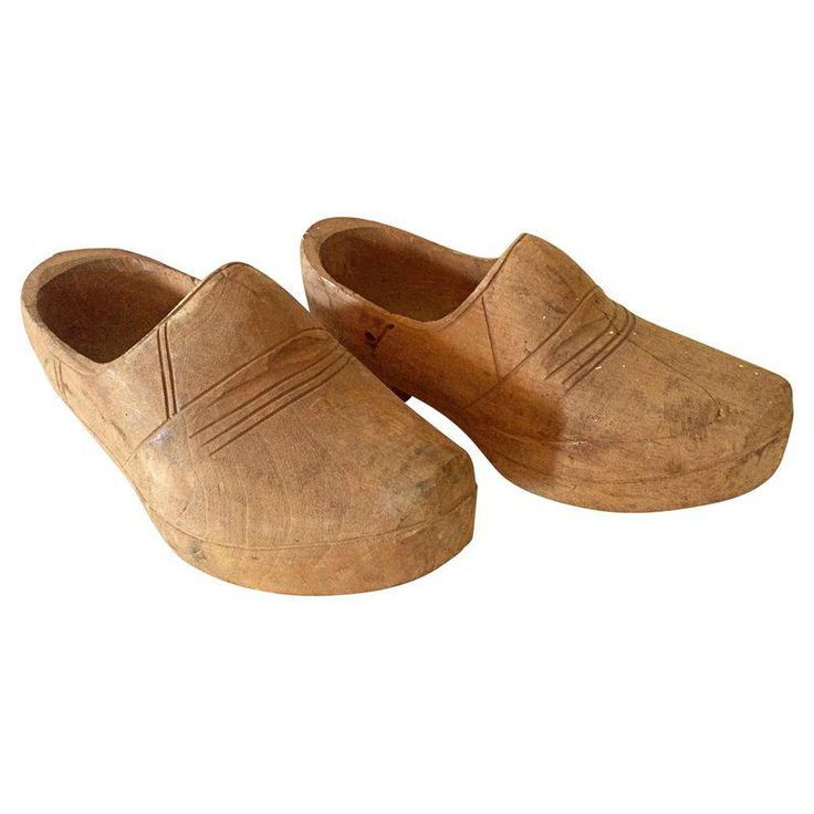 an old pair of wooden clogs on a white background