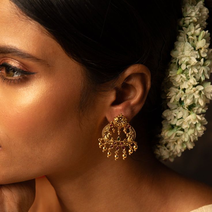 Description: Inspired by the beauty of nature, Bhagya Chandbali earrings are a symphony of Indian motifs- from flower to the Iconic Indian bird peacock. Studded with Kempu stone, this gold-plated silver earring is a testament to the skill of our master artisans. This timeless chandbali earrings are finished with an array of gold plated loop drops- perfect for a modern and ethnic look. Product Information : Materials used: 925 Silver with Antique Plating Stones: Semi-precious stones Length: 4cm F Ceremonial Danglers For Diwali, Temple Jewelry Chandbalis Drop Earrings, Traditional Earrings With Intricate Design, Traditional Earrings For Celebration, Elegant Jewelry With Matching Earrings For Navratri, Elegant Navratri Festive Earrings, Festive Temple Jewelry Single Earring, Elegant Festive Earrings For Navratri, Bridal Earrings With Latkans For Gift