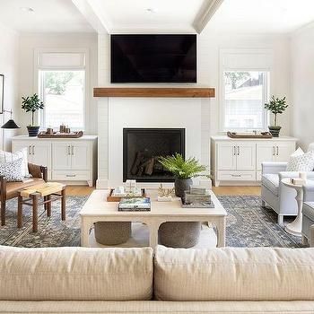 a living room filled with furniture and a flat screen tv mounted on the wall above a fireplace