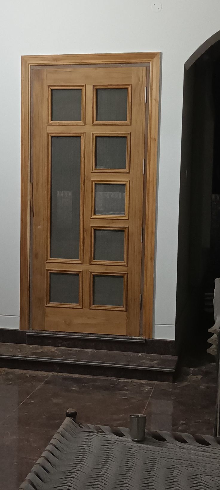 a large wooden door sitting next to a white wall