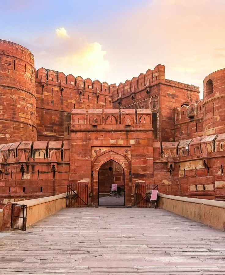 a large brick building with a gate and walkway leading to it's entrance area