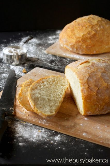 two loaves of bread sitting on top of a cutting board next to a knife