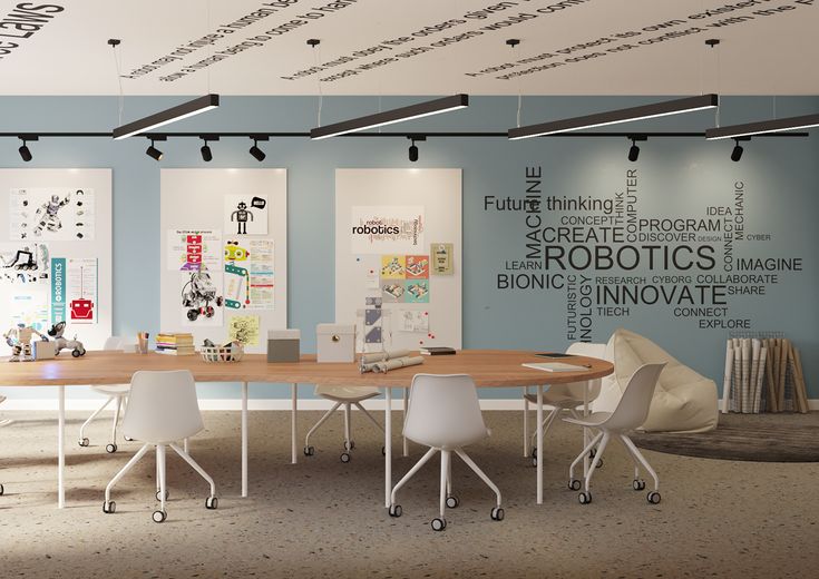 a conference room with blue walls and white chairs around a round wooden table surrounded by posters on the wall