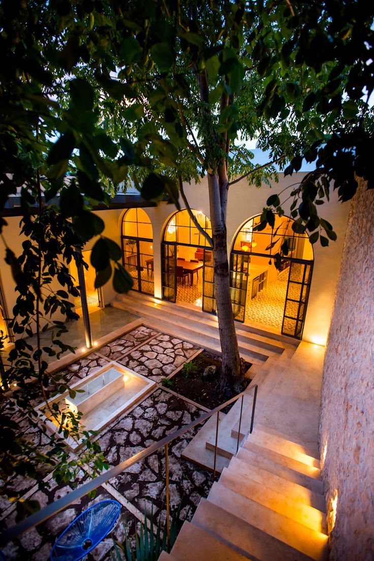 an outdoor area with stairs leading up to a tree and water feature in the center