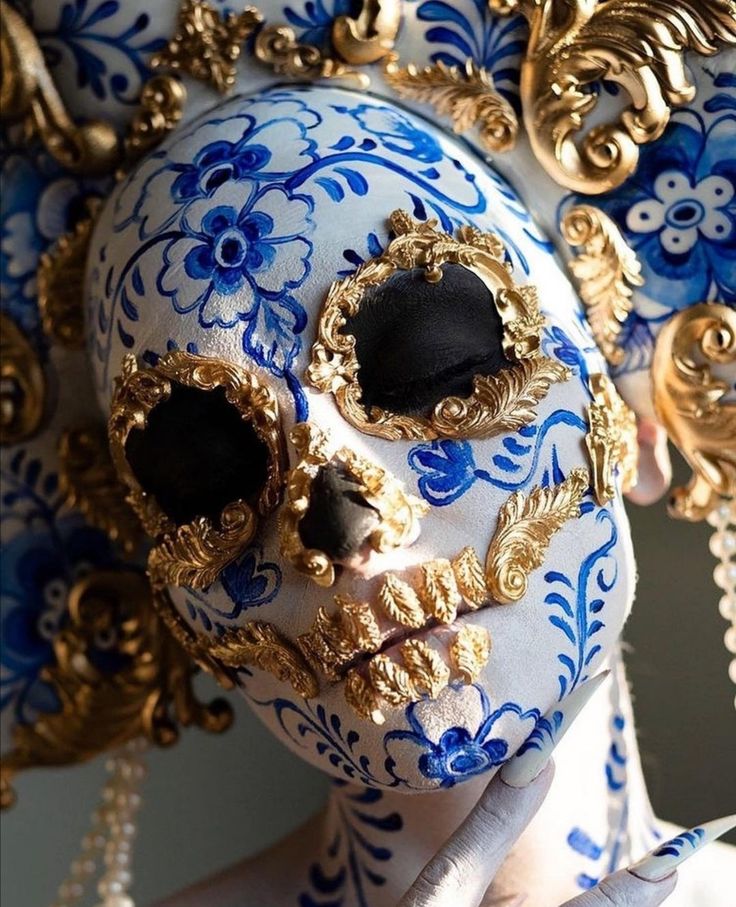 a blue and white mask with gold decorations on it