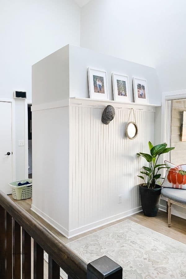 a living room with white walls and pictures on the wall, along with a couch