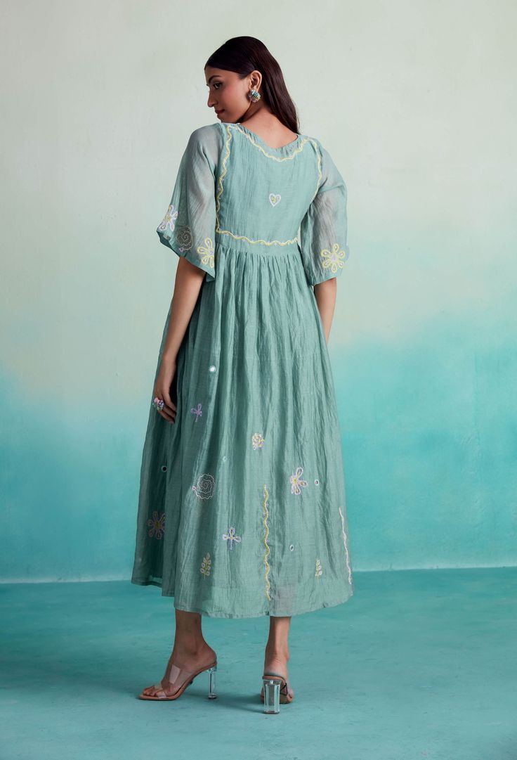 Introducing the enchantmint dress: embrace elegance and grace with this soft, lightweight chanderi dress in a refreshing mint color. Hand-embroidered with intricate motifs inspired by kutichi embroidery, this dress exudes a charming allure. Its flowy and dramatic design, complemented by pleats on the side, guarantees a show-stopping entrance at any gathering. Perfectly suited for get-togethers with loved ones, where delectable food and cherished family moments await. Step into enchantment with t Green Embroidered Anarkali Dress, Festive Pista Green Chanderi Dress, Bohemian Chanderi Festive Dresses, Bohemian Chanderi Dress For Festive Season, Bohemian Chanderi Dress For Festive Occasions, Summer Festive Anarkali Embroidered Dress, Festive Bohemian Chanderi Dress, Anarkali Dress With Chikankari Embroidery In Pista Green, Embroidered Anarkali Maxi Dress For Summer