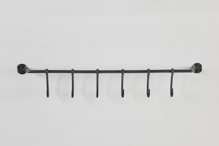 a metal rack with five hooks on it