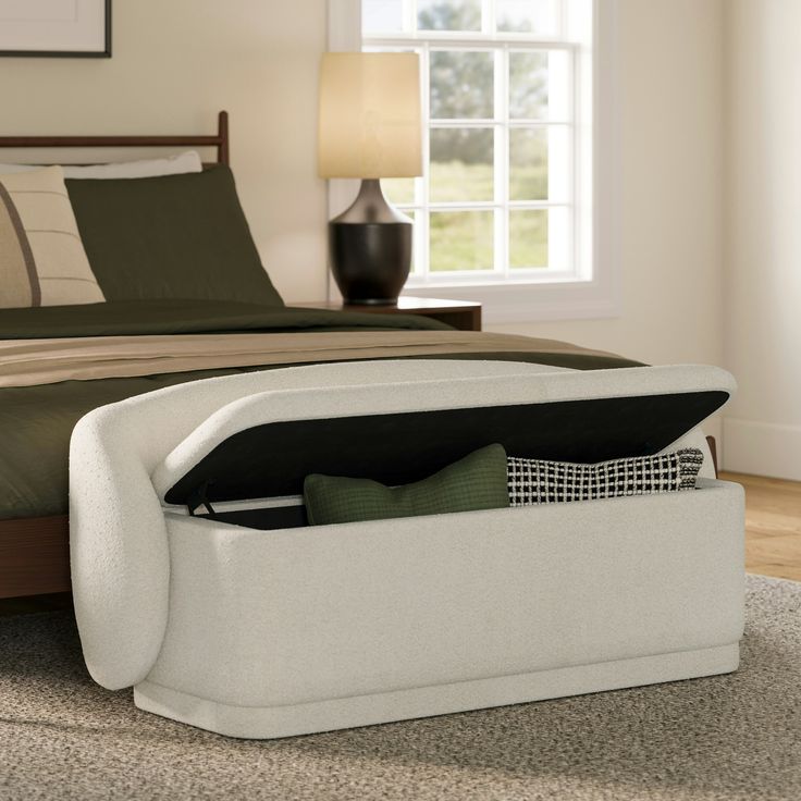 a bed with a storage compartment underneath it in a living room next to a window