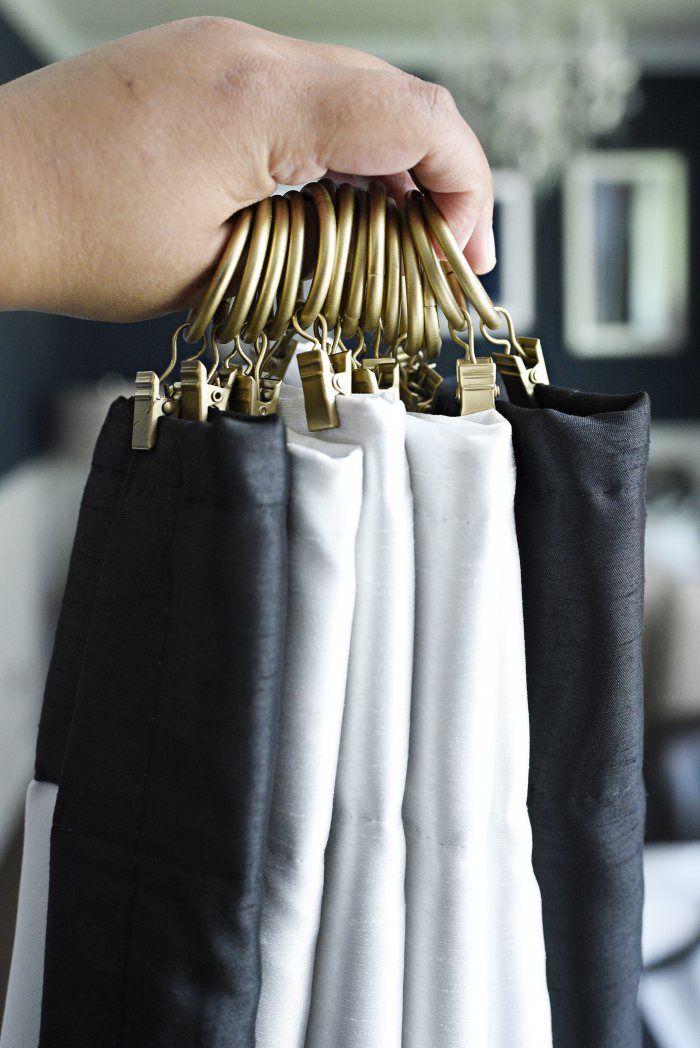 a person is holding several pairs of pants with gold clips on them and hanging from the side