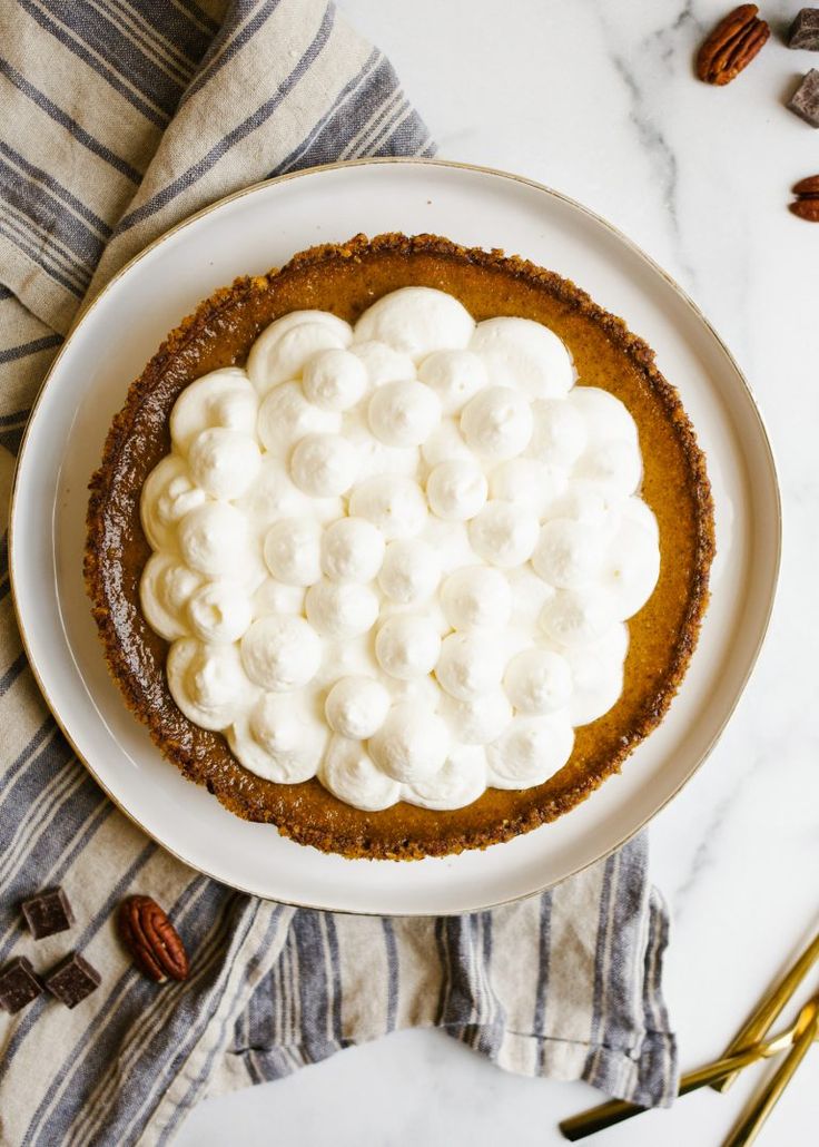 a white plate topped with a pie covered in whipped cream