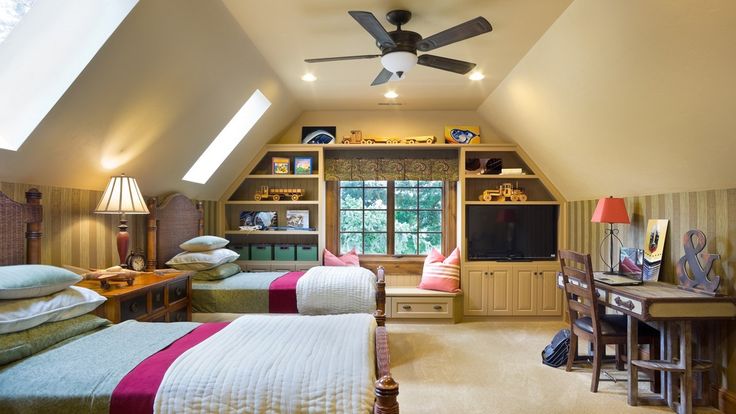 a bedroom with two beds and a desk in front of a tv mounted on the wall