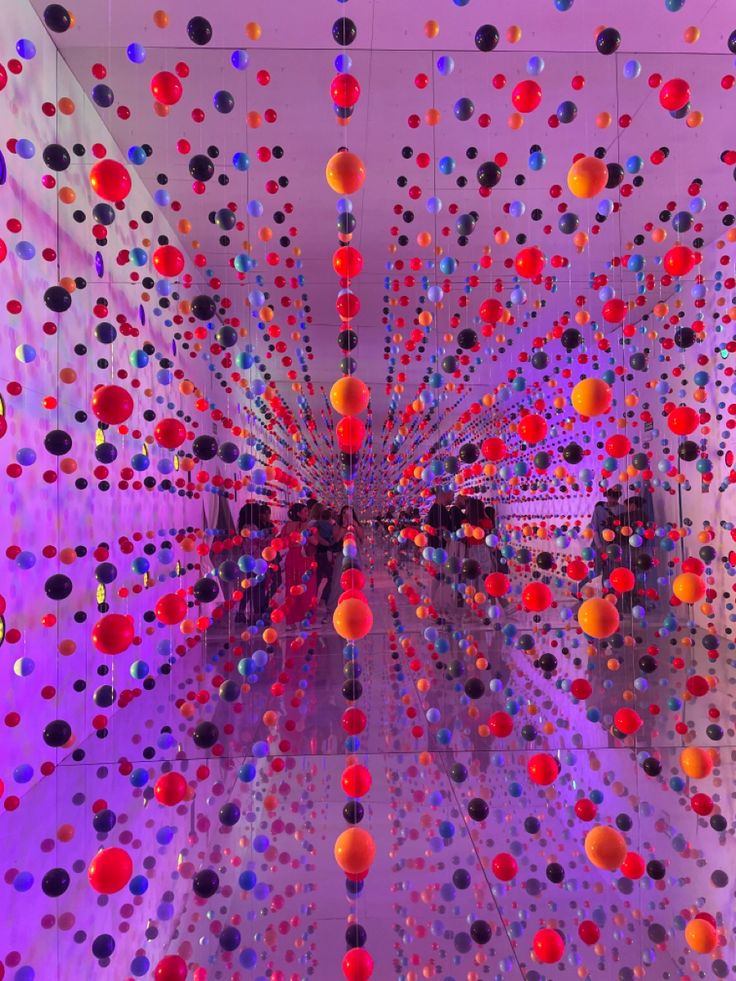 an art installation with colorful balls hanging from the ceiling