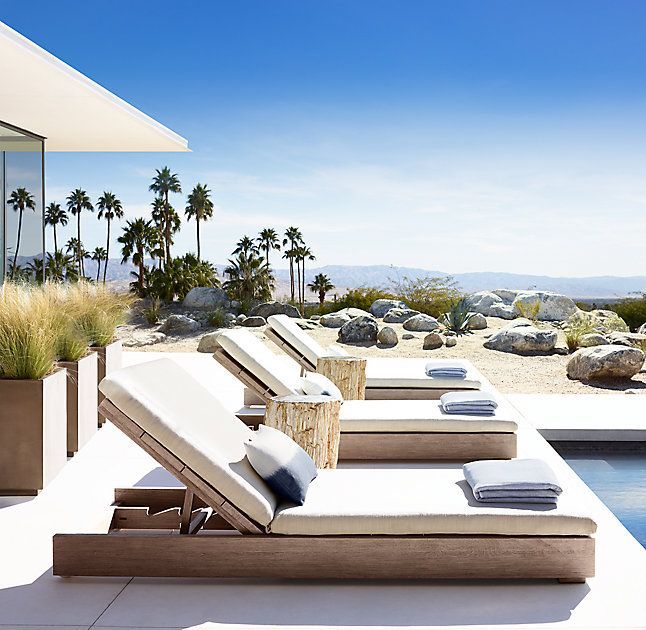 an outdoor pool with lounge chairs and palm trees