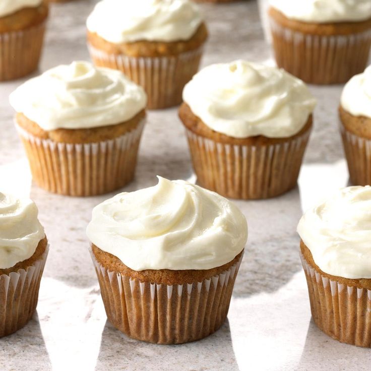 cupcakes with white frosting sitting on a counter top, ready to be eaten