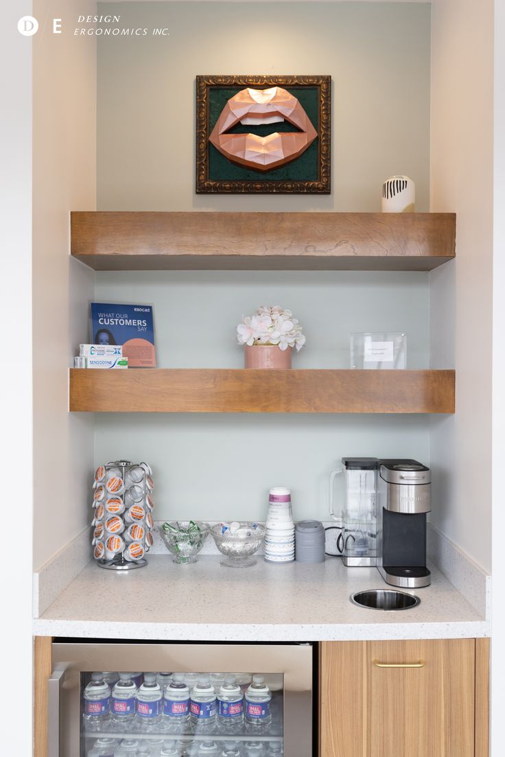 the shelves in this kitchen are filled with drinks and snacks, along with an art piece