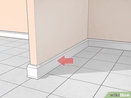 an empty room with tile floors and a red arrow pointing to the corner on the wall