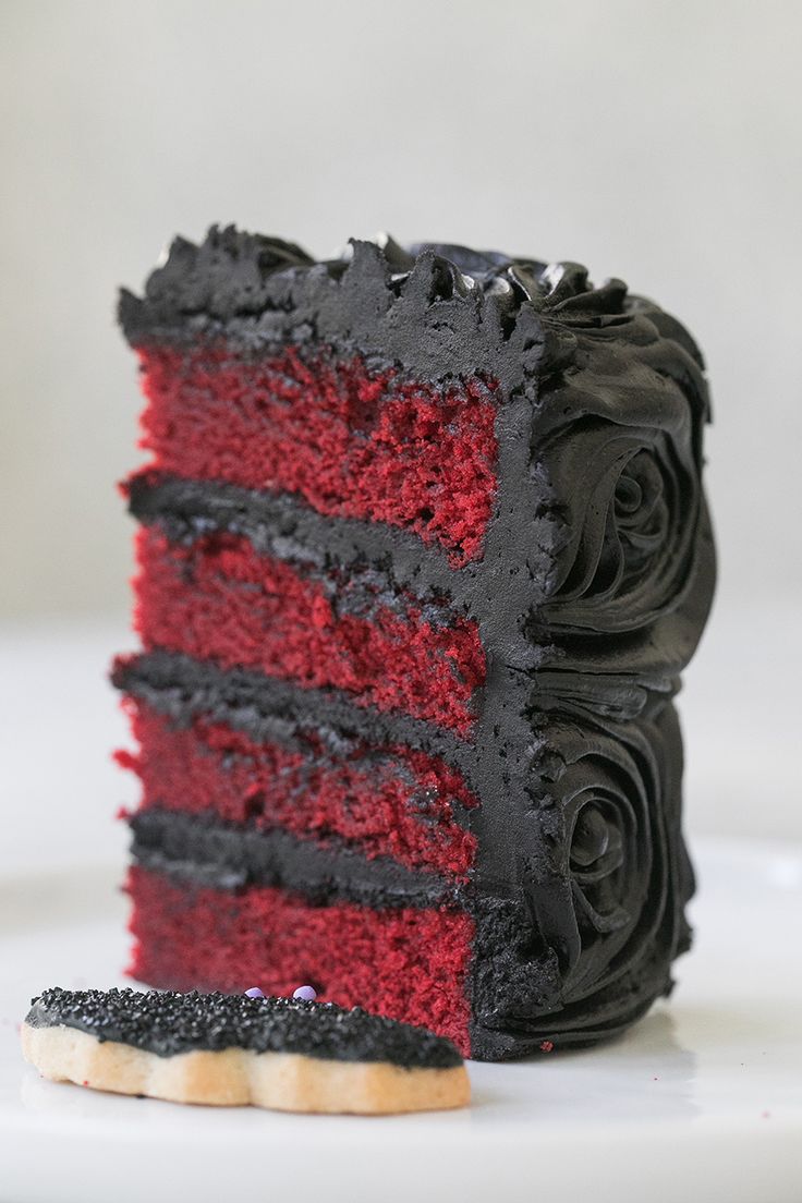 a slice of red velvet cake with black icing