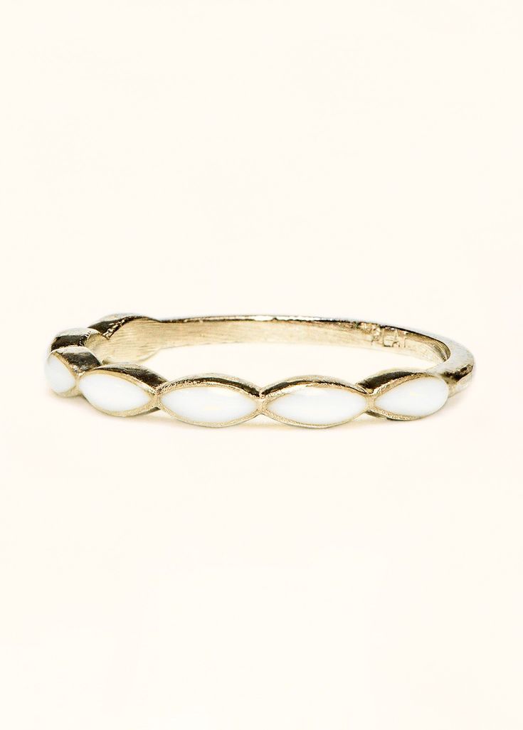 a gold ring with white stones on the inside, and an oval design in the middle