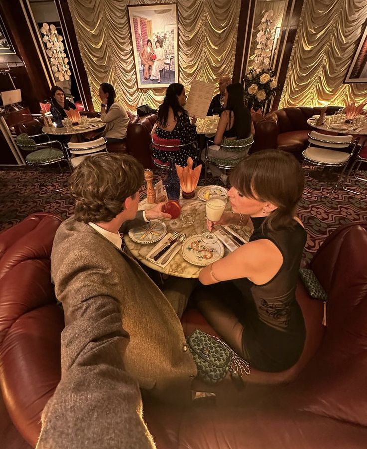 three people sitting at a table with plates of food