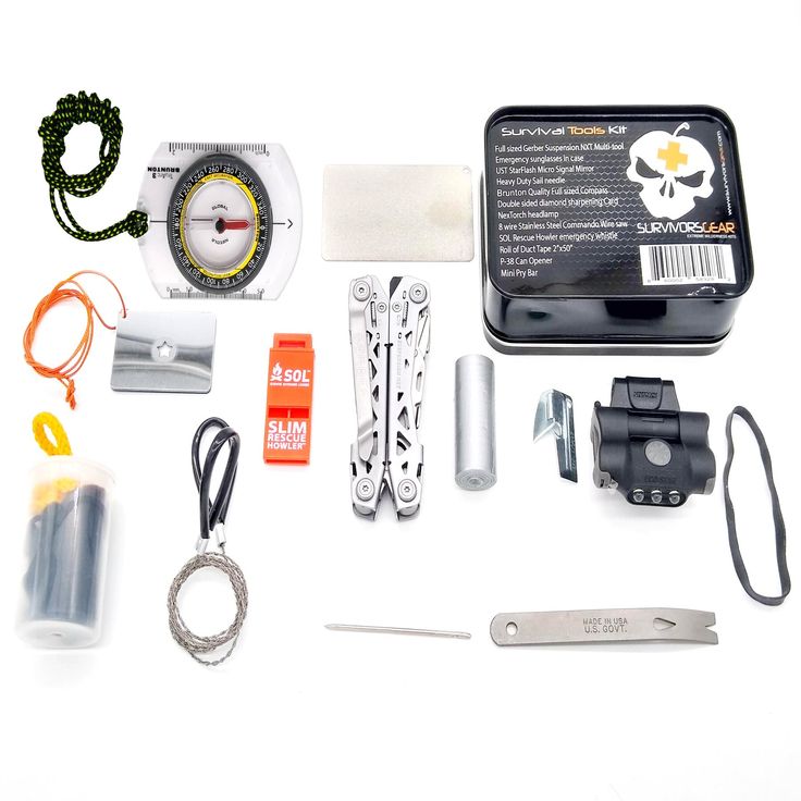 the contents of a survival kit laid out on a white table with scissors and other items