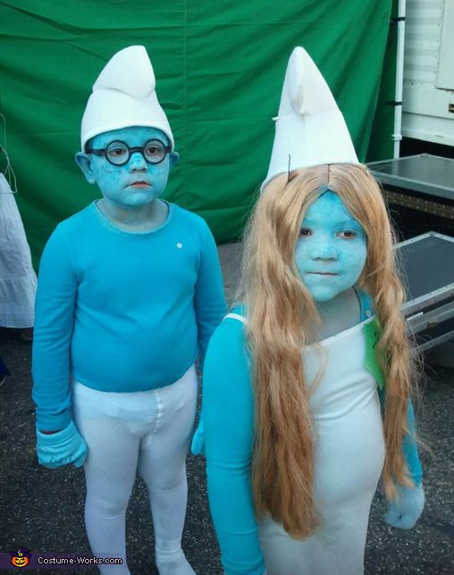 two children with blue paint on their faces are standing in front of a green tent