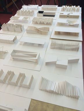 several pieces of paper sit on top of a table with wooden slats in the shape of buildings