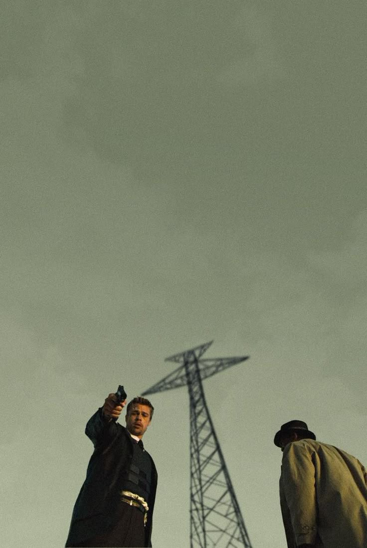 two men standing next to each other in front of a radio tower