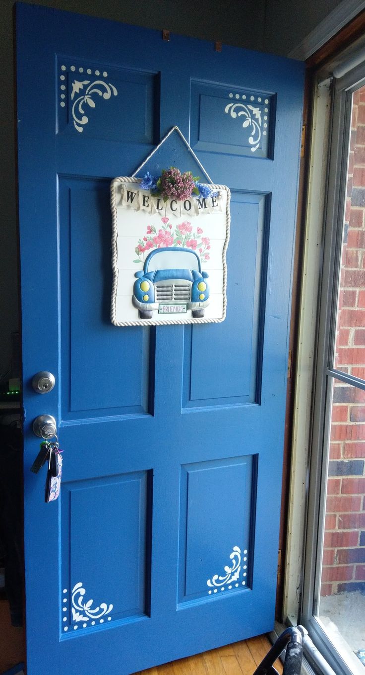 a blue door with a welcome sign hanging on it