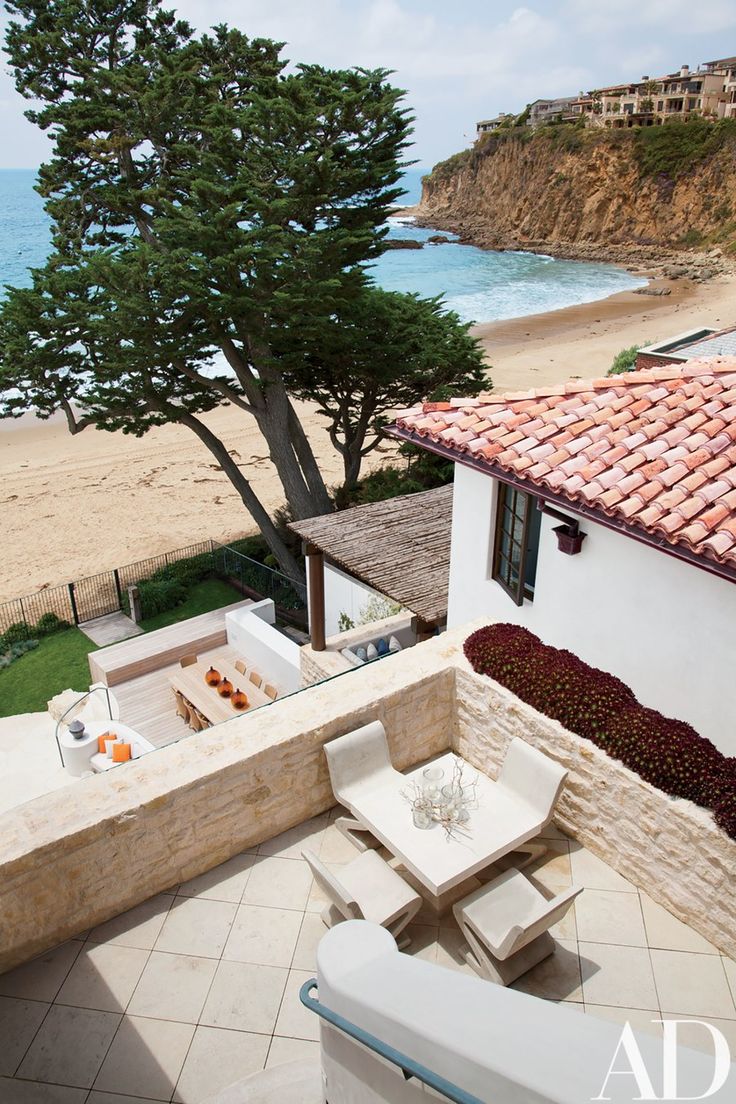 an aerial view of a patio with chairs and tables next to the beach in front of it