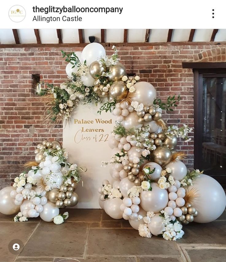 balloons and flowers are arranged in front of a sign