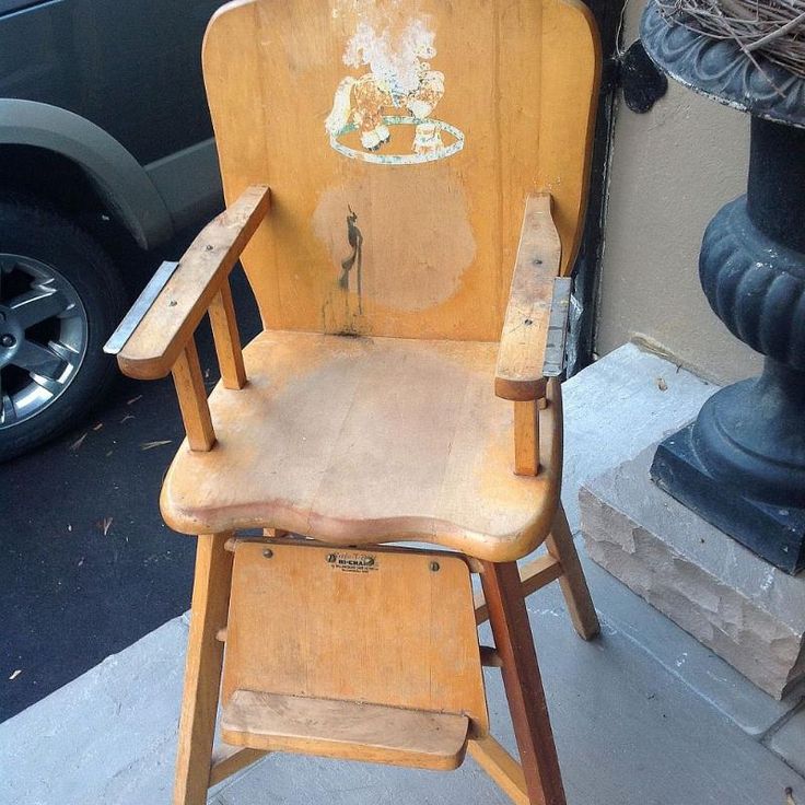 an old wooden chair sitting next to a black car