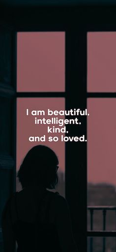 a woman standing in front of a window with the words i am beautiful, intelligent kind, and so loved