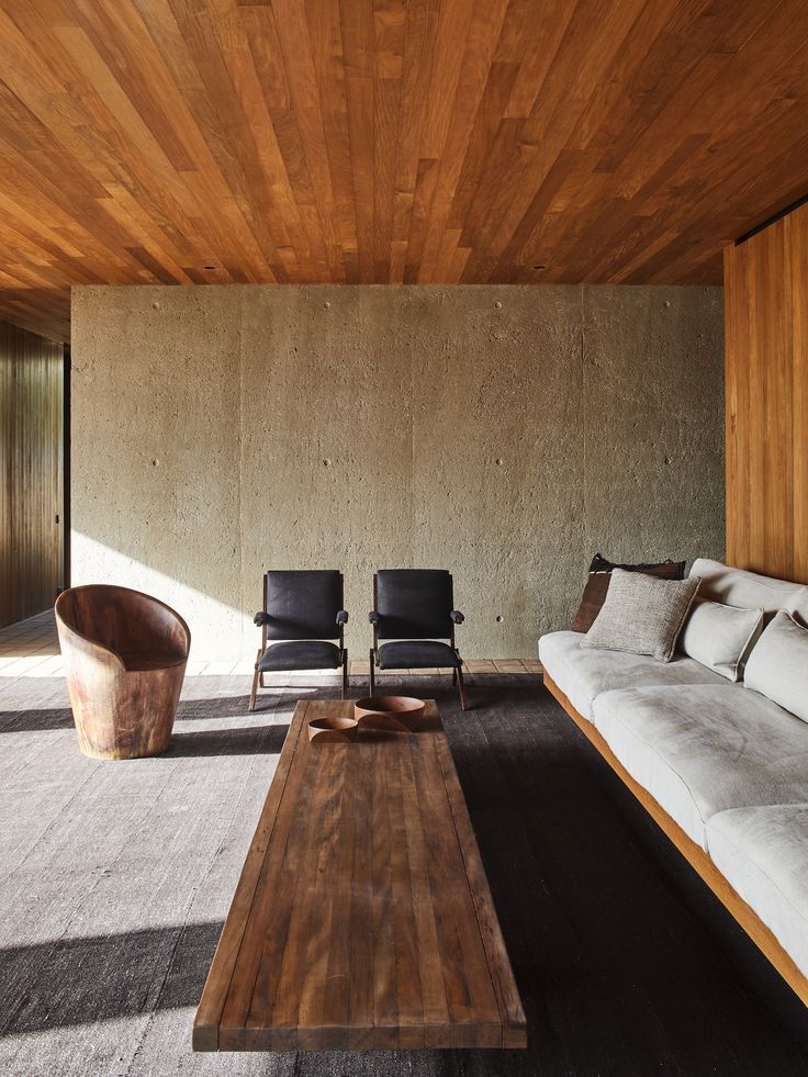 a living room filled with furniture and wooden walls