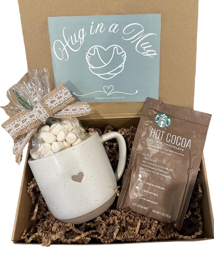 a starbucks coffee mug with marshmallows in it and a bag of cocoa