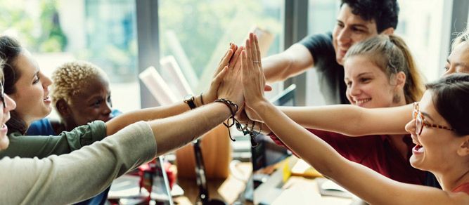 a group of people holding their hands together