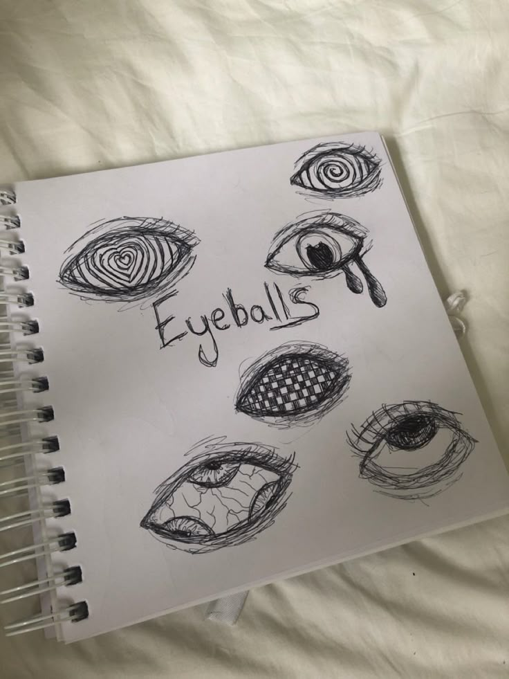 an open notebook with eyeballs drawn on it and the words eyeballs written in black ink